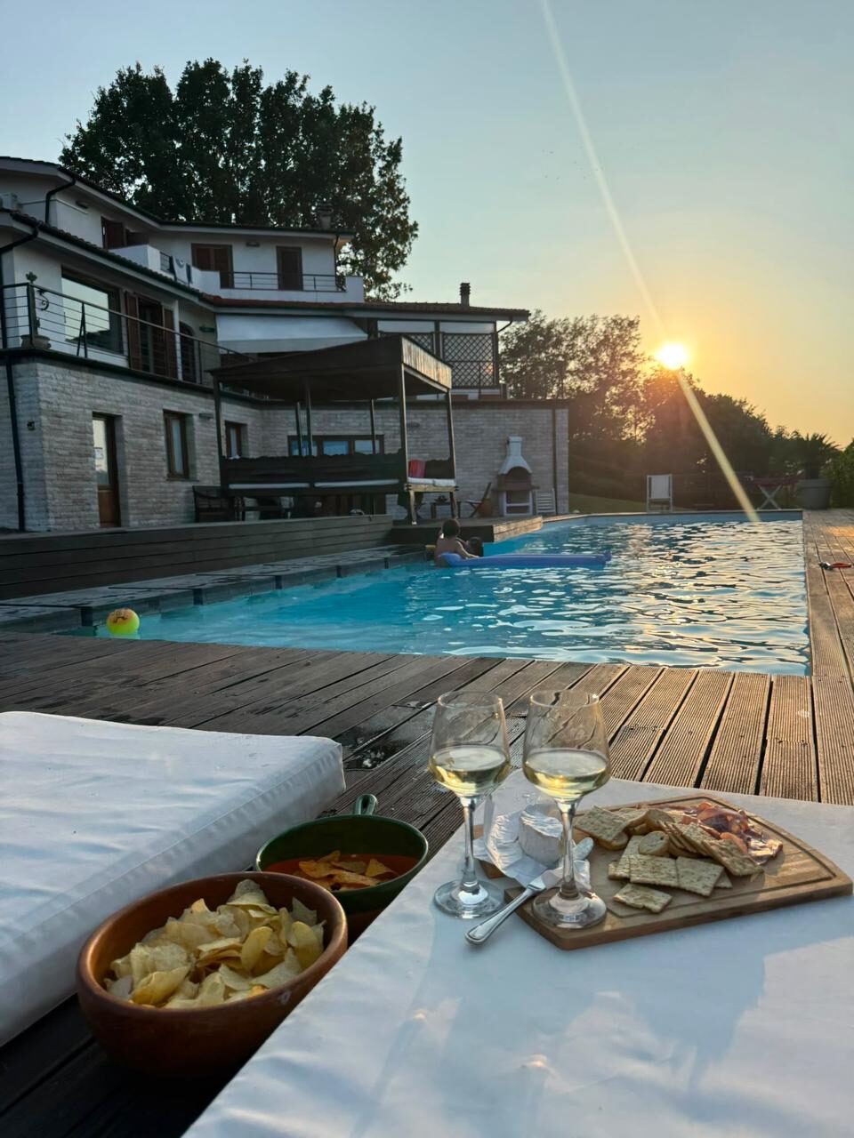 Aperitivo al tramonto a bordo piscina con la villa sullo sfondo, Tuscia