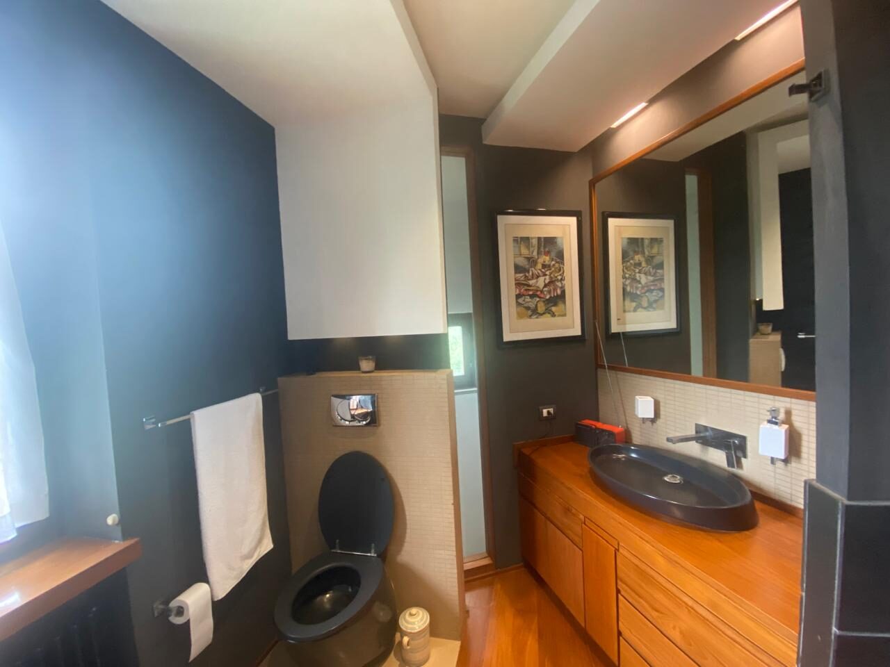 Bagno di design nero con doppio lavabo in pietra e mobile in legno