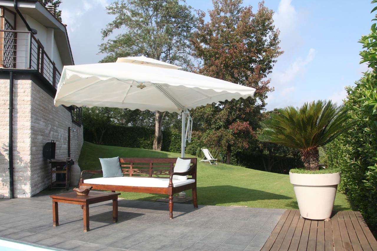 Divano da giardino sotto l’ombrellone con palma e prato, Villa Coccinella