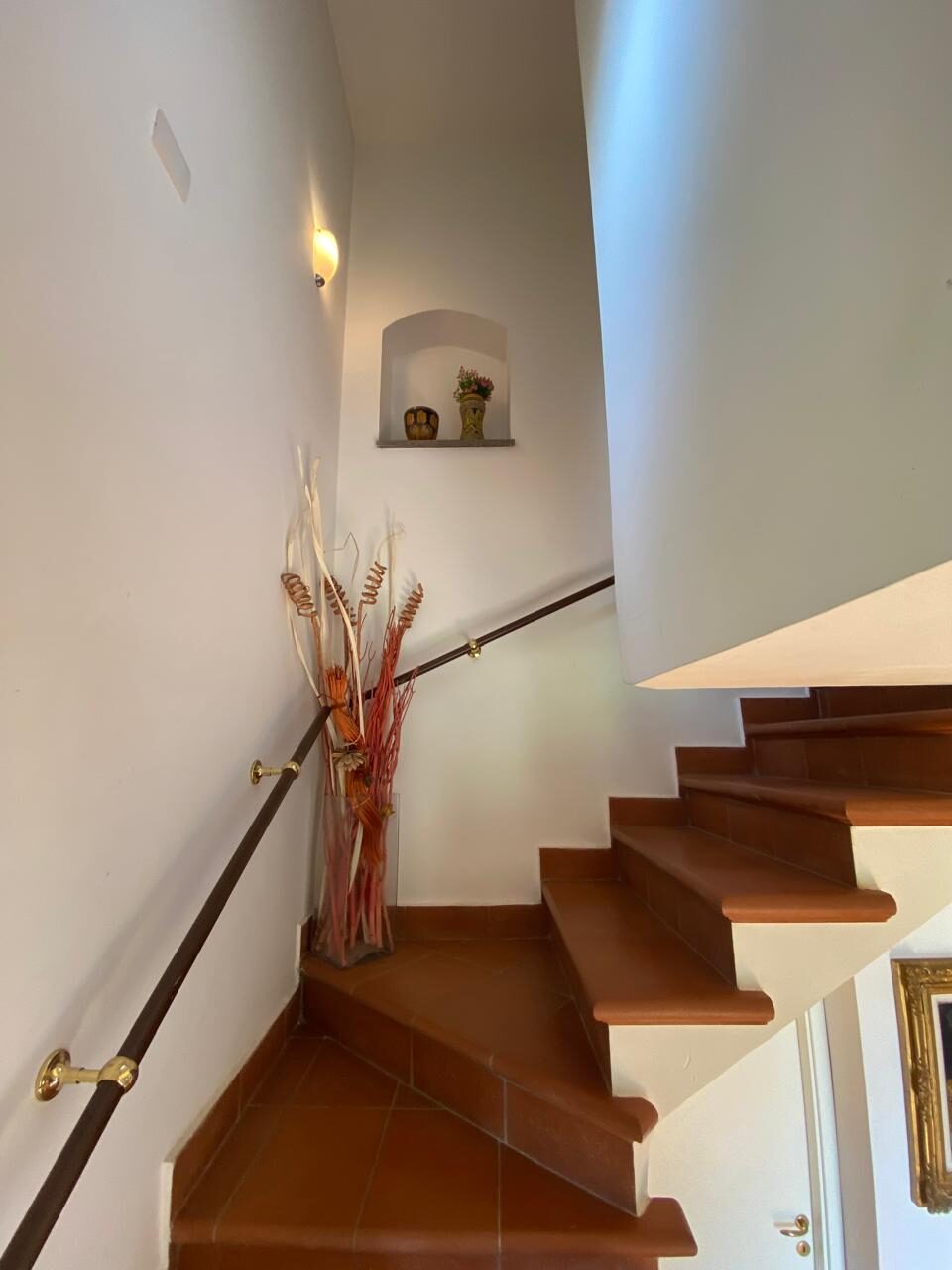 Scala interna con nicchia illuminata e corrimano in ferro
