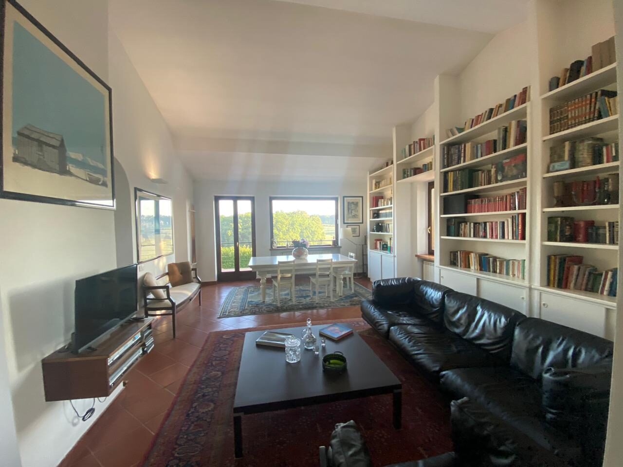 Soggiorno con TV, libreria a tutta parete e divani in pelle, Villa Coccinella