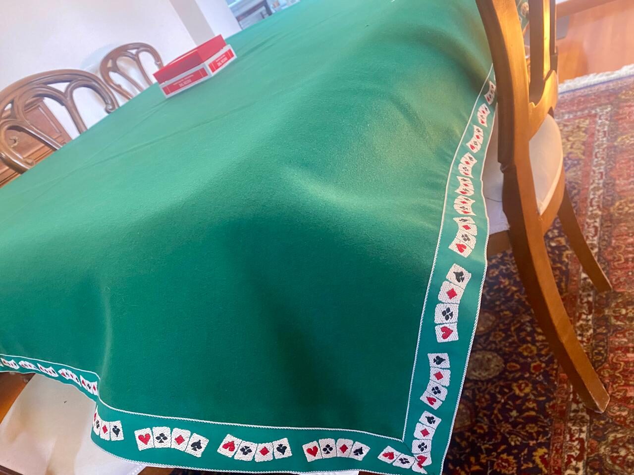 Tavolo da gioco con panno verde e bordo a carte da gioco, dettaglio