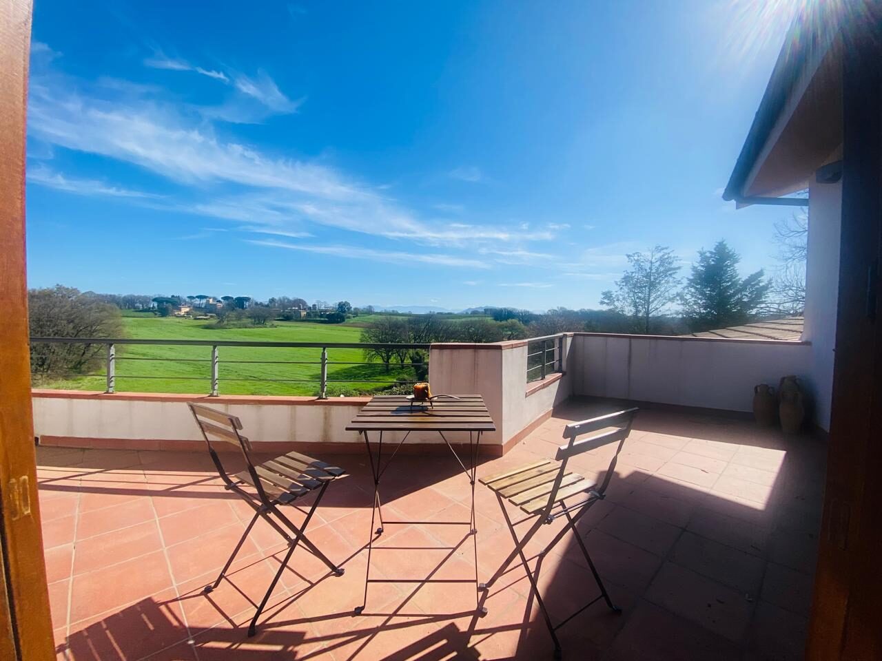 Terrazza in cotto con tavolino bistrot e vista sui campi, Colle Farnese